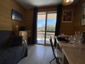 A cozy room with a bed, a desk, and a dining table.