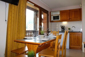 A compact kitchen with wooden cabinets, a microwave, and a sink.