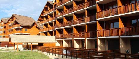 A multi-story hotel with wooden balconies and a covered outdoor area.