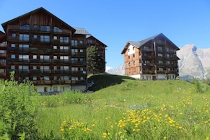 Un hotel in stile chalet in legno, con numerosi balconi e uno sfondo montuoso.