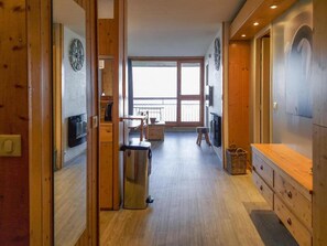 A spacious kitchen with wooden cabinets, a stainless steel kettle, and a large window offering a view of the outdoors.