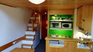 A narrow hallway leading to a kitchen with wooden cabinets, a microwave, and a sink. - 300m from ski slopes, 5th floor, balcony, tv, 33m², Les Arcs (Les Arcs)