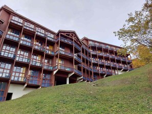 Hotel de vários andares com varandas e telhado inclinado.