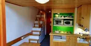 A narrow hallway leading to a kitchen with wooden cabinets, a microwave, and a sink. - 300m from ski slopes, 5th floor, balcony, tv, 33m², Les Arcs (Les Arcs)