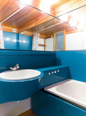 A bathroom with a blue sink, a white bathtub, and a wooden ceiling. - 50m from ski slopes, 3rd floor, tv, 30m², Les Arcs (Les Arcs)