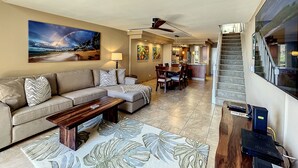 A spacious living area with a sofa, coffee table, and a dining area with chairs and a table. -  F507 - 2 Bedroom/2 Bath - Steps from the Beach, Super Clean! (Lahaina)