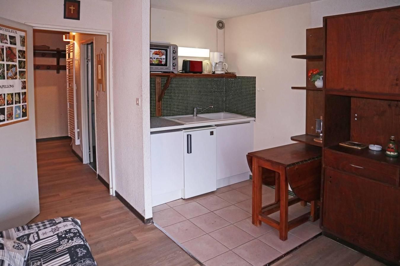 Eine kleine Küche mit Mikrowelle, Spüle und Holzschränken.