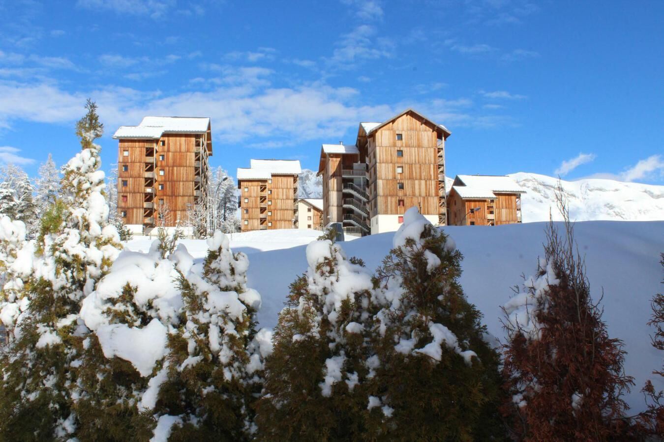 Montaña nevada con edificios de madera, probablemente un centro de esquí.