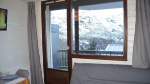 Une pièce avec une grande fenêtre, un canapé et une table.