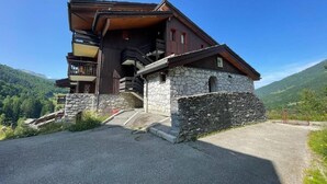 A wooden chalet with stone walls, a balcony, and a staircase leading to the entrance. - 200m from ski slopes, 1st floor, balcony, ski locker, 31m², Valmorel (Valmorel)