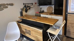 A compact kitchen with a wooden countertop, white chairs, and a built-in oven. - Ground floor, terrace, tv, ski locker, 22m², Pralognan-la-Vanoise (Pralognan-la-Vanoise)