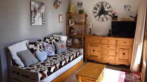 Un salon chaleureux avec un canapé, un meuble en bois et une horloge murale.