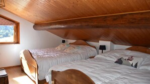 A bedroom with two wooden beds, a window with a view of trees, and a wooden ceiling. - Chalet, terrace, balcony, tv, 200m², Pralognan-la-Vanoise (Pralognan-la-Vanoise)