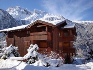 A wooden chalet with a balcony, surrounded by snow-covered mountains. - 100m from ski slopes, 2nd floor, balcony, tv, 56m², Pralognan-la-Vanoise (Pralognan-la-Vanoise)