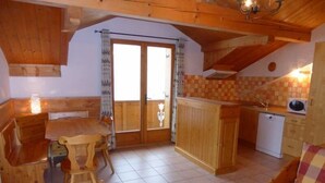 A cozy cabin interior with a dining area, a kitchen, and a living space.