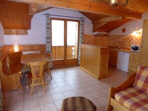 Een knus interieur van een chalet met een eethoek, een keuken en een zithoek.