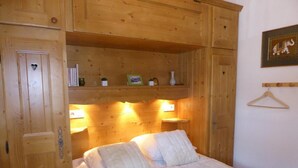 A wooden room with a bed, shelves with books and decorative items, and a framed picture on the wall. - 200m from ski slopes, Ground floor, terrace, tv, ski locker, 43m², Pralognan-la-Vanoise (Pralognan-la-Vanoise)