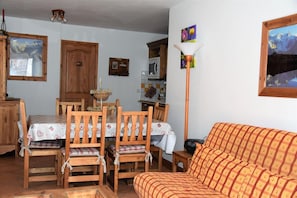 Ein gemütliches Wohnzimmer mit einem Holzesstisch, Stühlen und einer Couch.