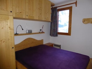 A room with a bunk bed, a desk with a lamp, a window with a view, and a wooden headboard. - 100m from resort center, 2nd floor, balcony, tv, 38m², Pralognan-la-Vanoise (Pralognan-la-Vanoise)