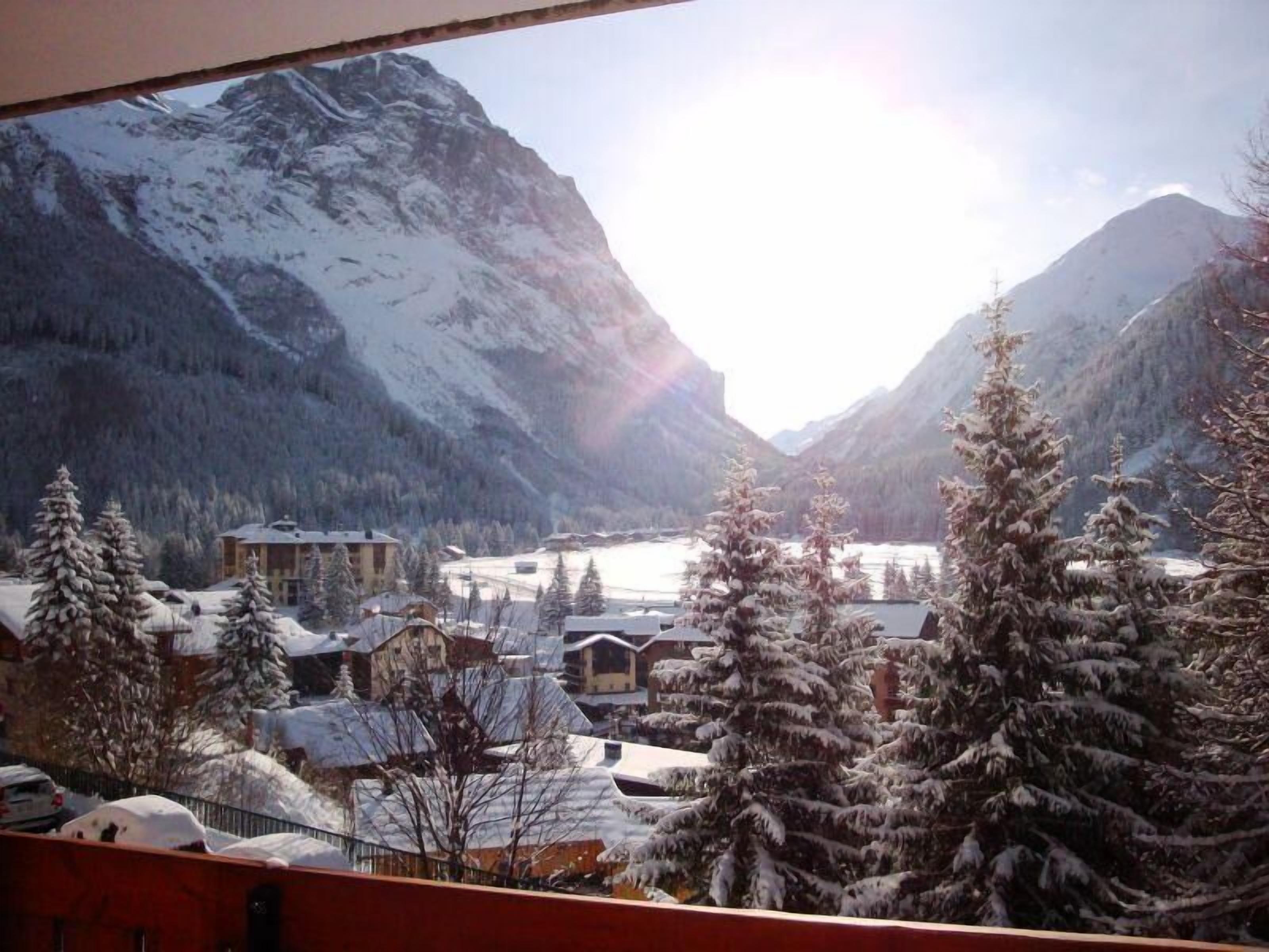 Eine Berglandschaft mit schneebedeckten Bäumen und Gebäuden.