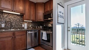 Una cocina moderna con armarios de madera, electrodomésticos de acero inoxidable y salpicadero.