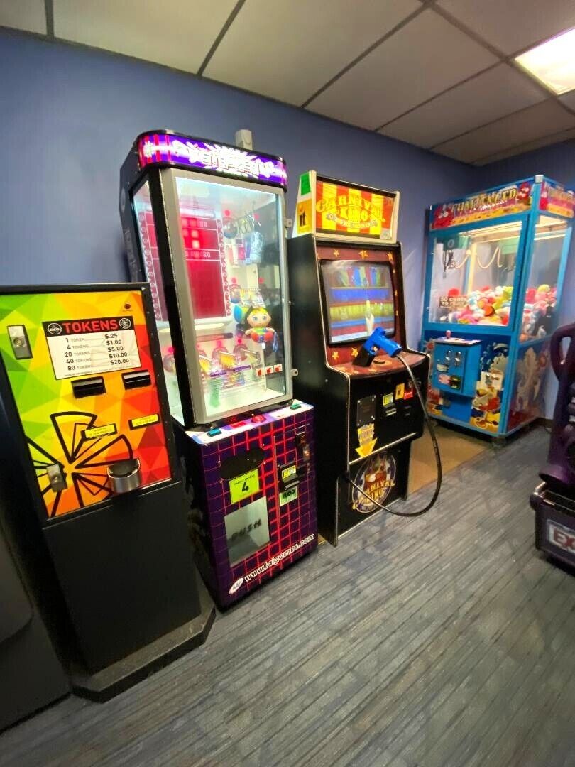 A row of arcade machines against a blue wall.