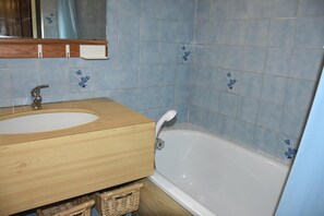 A bathroom with a wooden vanity, a white sink, and a white bathtub. - 3rd floor, balcony, tv, ski locker, 22m², Pralognan-la-Vanoise (Pralognan-la-Vanoise)