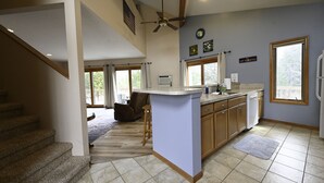 Una cocina con una isla central, armarios de madera y vistas al exterior.