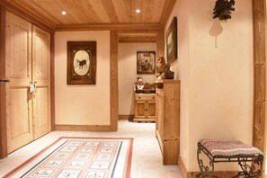 A hallway with wooden cabinets, a framed deer picture, and a small bench.