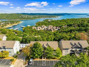 A residential area with houses surrounded by trees and a body of water.