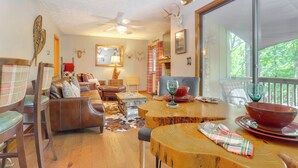 A cozy living room with a fireplace, leather furniture, and a large window overlooking greenery. - 1/2 Mi to Marina: Lake Arrowhead Condo! (Waleska)