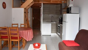 Un espace de vie compact comprenant un coin repas, une kitchenette et un canapé.