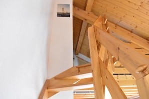 Estructura de techo de madera con vigas y un pequeño cuadro enmarco.