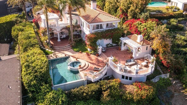 Une villa luxueuse dotée d’une grande piscine, de nombreux espaces de détente en plein air et d’un aménagement paysager luxuriant.