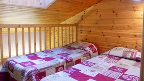 A cozy cabin with two beds, wooden walls, and a sloped ceiling. - 10m from ski slopes, 3rd floor, balcony, ski locker, 41m², Méribel-Mottaret (Méribel - Les Allues)