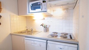 A compact kitchen with a microwave, stove, sink, and dishwasher. - 130m from ski slopes, 4th floor, balcony, parking, tv, ski locker, 35m², La Norma (La Norma)