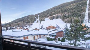 Un village de montagne enneigé, avec des bâtiments en bois et une piste de ski.