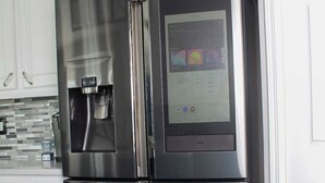 Een roestvrijstalen koelkast met een waterdispenser en een digitaal scherm.