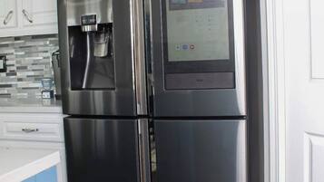 Un réfrigérateur en acier inoxydable doté d’un distributeur d’eau et d’un écran numérique.
