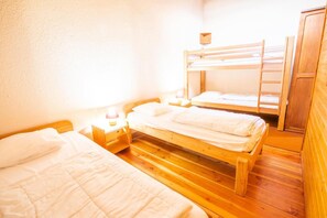 A room with two wooden bunk beds, a nightstand with a lamp, and a wardrobe. - 280m from resort center, 1st floor, balcony, parking, tv, 47m², La Norma (La Norma)