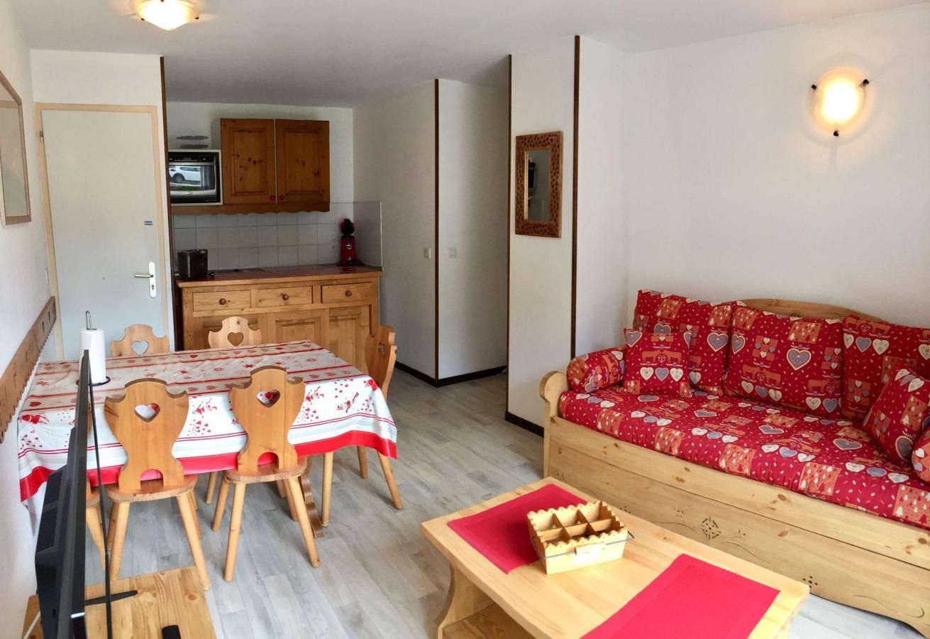 A compact living space with a dining area, a sofa, and a television.