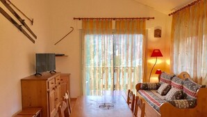 Un salon chaleureux avec une table à manger en bois, un canapé et un téléviseur.