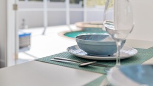 A dining area with a table set for two, a glass of water, and a bowl. - Sunny House with heated pool, 12min drive to Engelwood Beach, Port Charlotte FL (Port Charlotte)