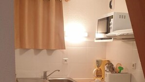 A compact kitchen with white cabinets, a built-in microwave, a sink, and a dishwasher. - 100m from ski slopes, 2nd floor, balcony, parking, tv, 54m², La Norma (La Norma)