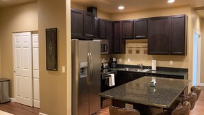 Una cocina moderna con armarios de madera oscura, electrodomésticos de acero inoxidable y una encimera de granito.