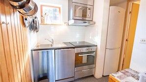 Cocina compacta con fregadero, estufa, microondas y refrigerador.