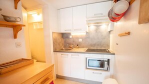 A compact kitchen with white cabinets, a built-in oven, and a sink. - 280m from resort center, 1st floor, balcony, parking, tv, 54m², La Norma (La Norma)