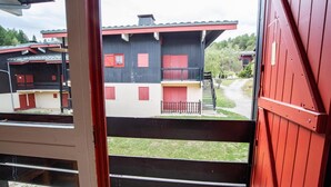 A view of a building with a red door, a balcony, and a staircase leading to a second floor. - 280m from resort center, 1st floor, balcony, parking, tv, 54m², La Norma (La Norma)