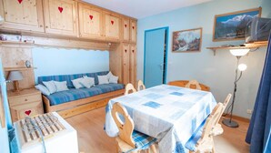 A cozy room with a bed, a dining table, and a kitchenette. - 130m from ski slopes, 4th floor, balcony, parking, tv, ski locker, 35m², La Norma (La Norma)