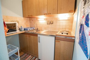 Compact kitchen with a dishwasher, sink, and stove.